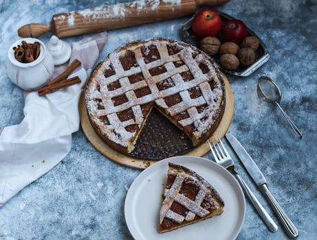 Tarte aux pommes maison avec une croûte en treillis, servie avec des pommes, des noix et des épices.